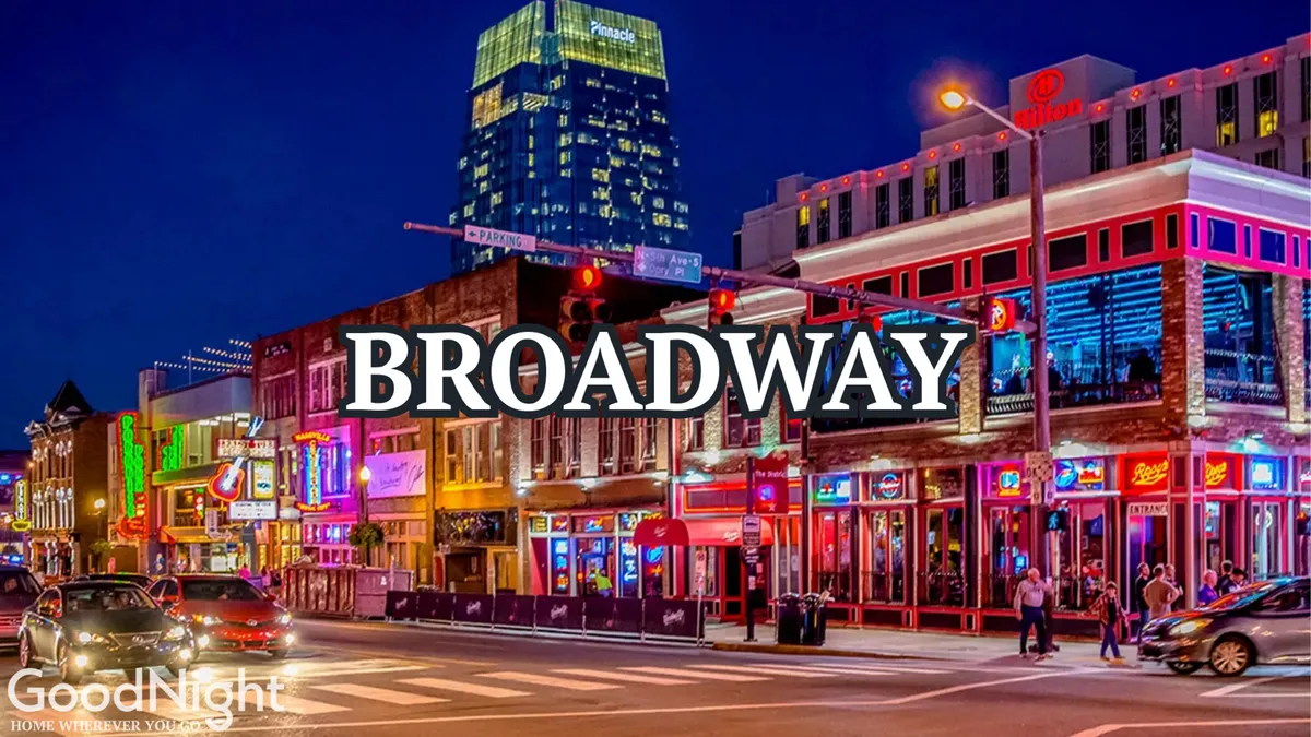 This image captures the electric energy of Nashville's famous Broadway district at night, with bright neon signs illuminating a busy street filled with people and cars. The vibrant scene hints at live music venues, bustling nightlife, and the excitement that defines the city's legendary entertainment strip.